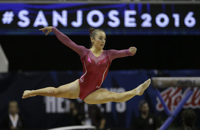 A Girl Gymnast in apink gymnastic swimsuit makes an action in a show