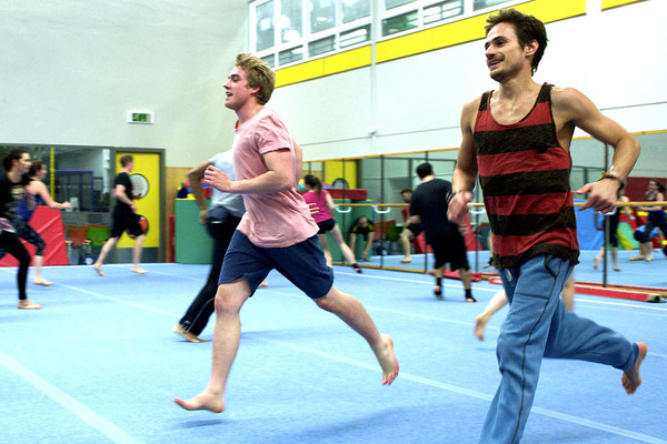 Group of male gymnasts running in a trianing session