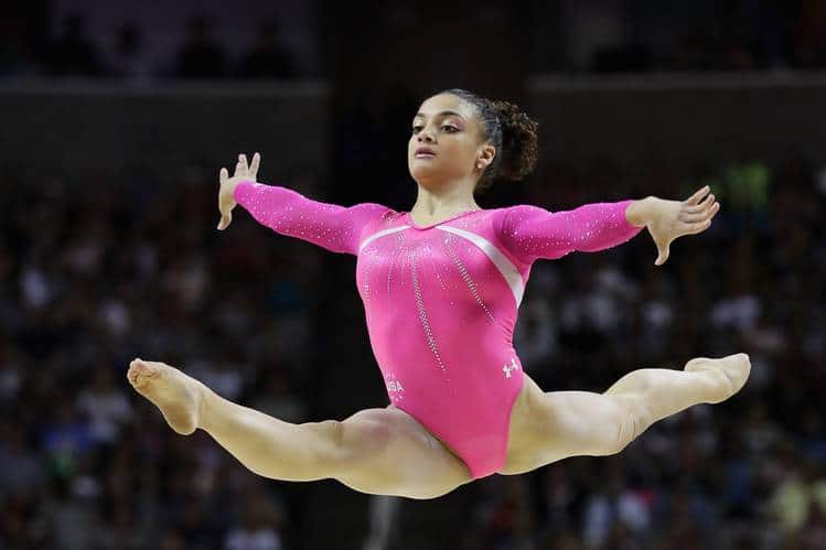 A beautiful young girl gymnast in a pink gymnastic swimsuit